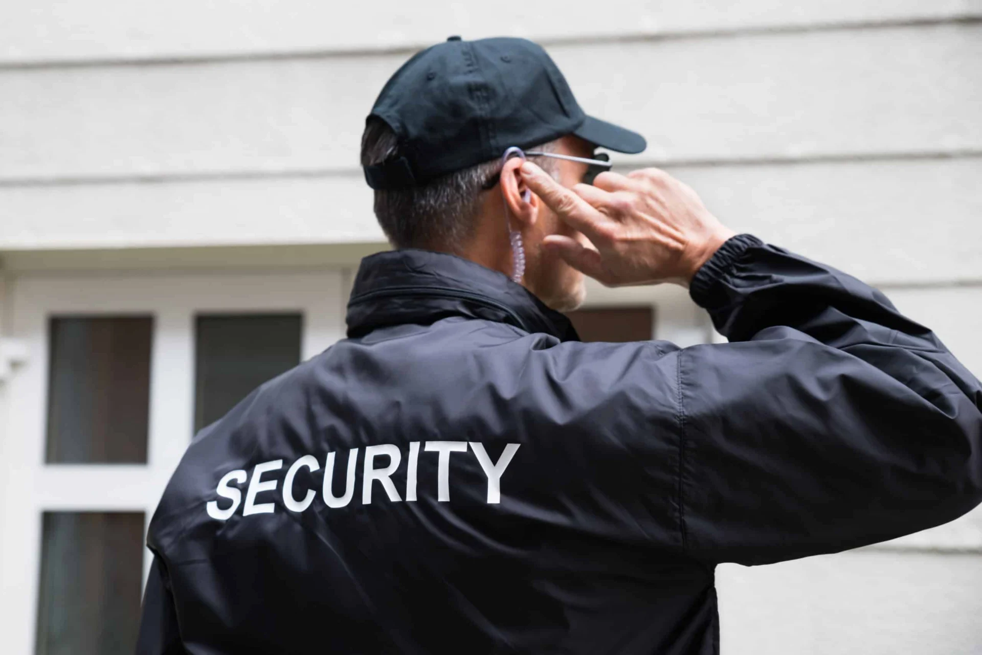 Security Guard Listening To Earpiece Against Building Security Guard Listening To Earpiece Against Building church building
